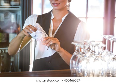 Waitress cleaning glasses in a restaurant - Powered by Shutterstock