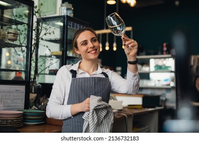 waitress cleaning wine glass in restaurant - Powered by Shutterstock