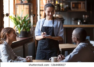 Waitress female welcoming diverse cafeteria pub guests african guy mixed race girl making order waiting staff writing wishes on notepad. Good service dining time, friends meets in public place concept - Powered by Shutterstock