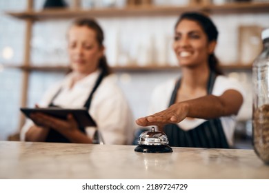 Waitress hands ringing service bell for a ready order in cafe, restaurant and coffee shop. Waitresses, servers and baristas serving, assisting or alerting waiter staff of prepared orders for people - Powered by Shutterstock