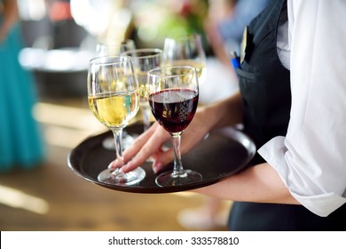 Waitress holding a dish of champagne and wine glasses at some festive event, party or wedding reception