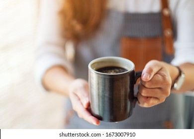 A Waitress Holding And Serving A Cup Of Hot Coffee In Cafe