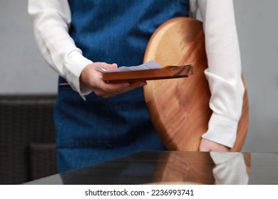 Waitress holding wooden tray with tips and receipt in cafe, closeup - Shutterstock ID 2236993741