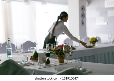 The waitress with long pigtail serves the banquet table in the restaurant - Shutterstock ID 1519100474