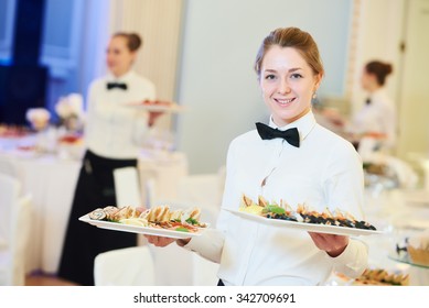 waitress occupation. Young woman with food on dishes servicing in restaurant during catering the event