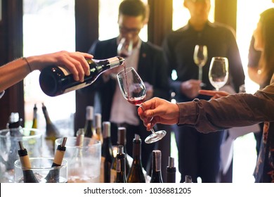 The waitress was pouring a glass of wine. In celebration of the team's success. - Shutterstock ID 1036881205