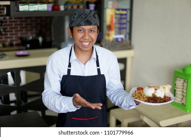 Waitress Restaurant Asian Man Holding Rise Or Nasi Lemak. Asian Man Smiling Waitress Holding Plate Of Meal In A Restaurant. Yogyakarta Indonesia. May 31, 2018