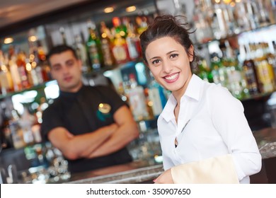 Waitress Restaurant Catering Service. Female Cheerful Restaurant Worker With Barman At Background