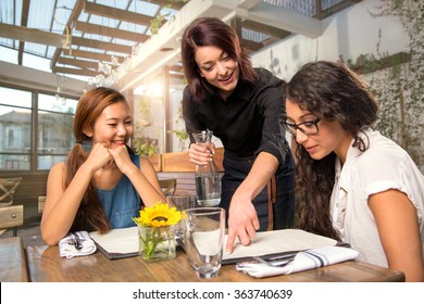 Waitress server helping client patron customer with menu order on sunny patio 