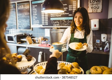 Waitress serving a cup of coffee in cafe