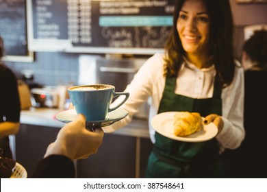 Waitress Serving A Cup Of Coffee In Cafe