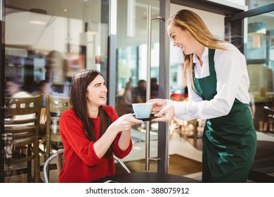 Waitress Serving A Cup Of Coffee In Cafe