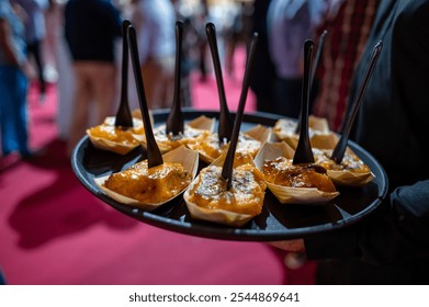 Waitress serving food at an elegant event with a red carpet - Powered by Shutterstock