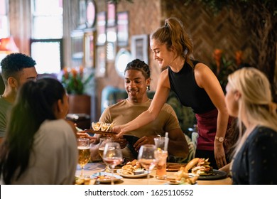 A waitress serving a meal to customers at a restaurant in Newcastle-Upon-Tyne. - Powered by Shutterstock