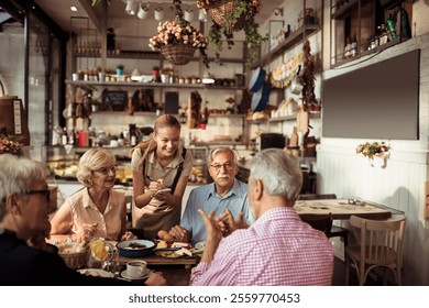 Waitress serving senior friends enjoying breakfast in a cozy cafe - Powered by Shutterstock