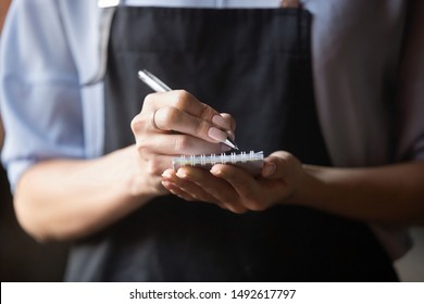 Waitress small cafe business owner wear apron uniform holding notepad pen write notes take order in restaurant, retail serving waiting staff, hospitality, good customer service concept, close up view