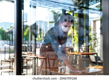 Waitress Staff with face mask using alcohol spray to cleaning Cafe, Restaurant, or Hotel Bar. Hygiene, safety  Antiseptic, cleanliness, healthcare, anti-virus, Anti Coronavirus (COVID-19) Concept. - Powered by Shutterstock