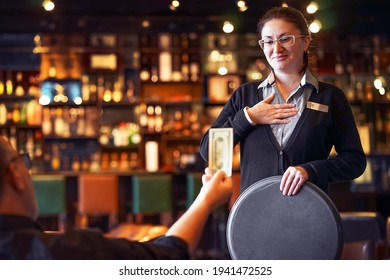 Waitress takes the tip. The waiter female receives a tip from the client at the hotel bar. The concept of service