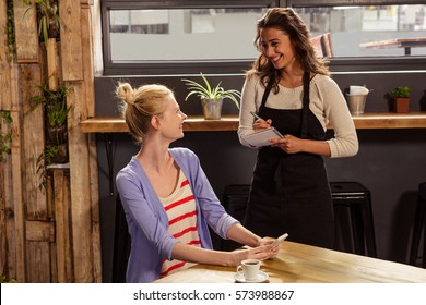 Waitress taking order of a woman in the cafe