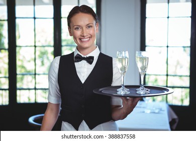 Waitress with a tray of flute of champagne in a restaurant