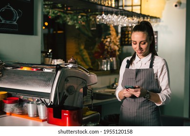 waitress using mobile phone in restaurant - Powered by Shutterstock