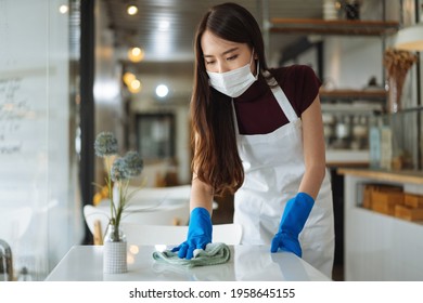 Waitress Wearing Face Mask Cleaning Table In Coffee Shop Restaurant