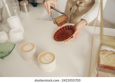 The waitress's hand puts the piece of cupcake on the table at a cafe standing behind bar counter - Powered by Shutterstock