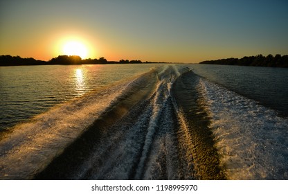 A wake of a boat at sunrise