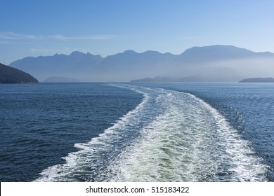 Wake Of A Ferry Near Vancouver Island With Mountains In The Background