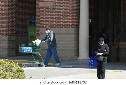 Wake Forest, NC/United States- 03/26/2020: 2 Elderly Shoppers Leave A Grocery Store With Face Masks As A Preventative Measure Against The Coronavirus Epidemic. 