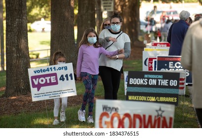 Wake Forest, NC-United States- 10-15-2020: A mother and her young daughters walk to the back of a long line for early voting. 