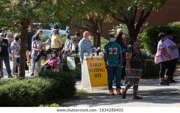 Wake Forest, NC/United States- 10/15/2020: A\
diverse group of North Carolina voters stand in very long lines on\
the first day of early\
voting.