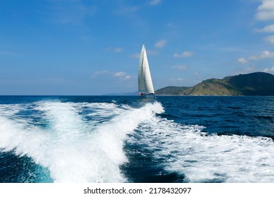 Wake From Motor Boat With Sailboat In Background Located In Phuket Island, Phuket, Thailand.