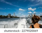 wake from Rotterdam Netherlands watertaxi vessel in high speed journey with female passenger. fast public transportation boat taxi service on water around Dutch city on sunny summer day in Holland