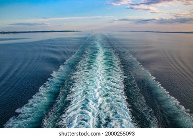 Wake Of A Ship Across Ocean While Sailing, On A Beautiful Day. Purple And Blue Light Reflecting On The Sea And Waves. Cruising The Baltic, North Sea And Fjords, Northern Europe. 