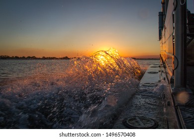 Wake splash from a boat with Sunset behind on the Zambezi River in Zambia