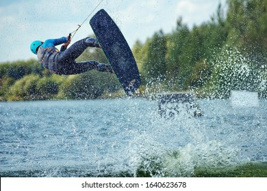 Wakeboarder Making Tricks. Low Angle Shot Of Man Wakeboarding On A Lake.