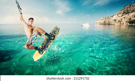 Wakeboarder making tricks on the sea in the sunny day. Wakeboarding on the beach.