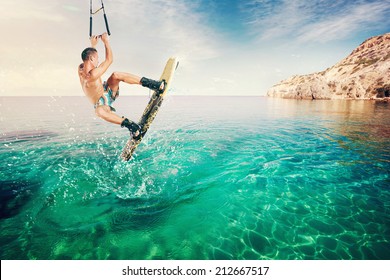 Wakeboarder Making Tricks On The Sea. Wakeboarding. Water Sports On The Beach.