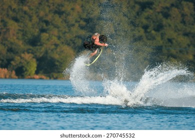 A Wakeskater Launches Off The Wake Behind A Boat.