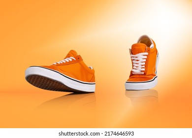 Walk. Modern unisex footwear, sneakers isolated on orange background. Fashionable stylish sports casual shoes. Creative minimalistic layout with footwear. Mock up for design, ad for shoe store - Shutterstock ID 2174646593