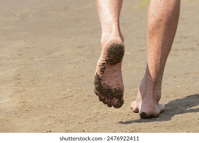 A walk on the beach.Men's feet close-up.A man walks barefoot on the sand.Travel and rest in summer. - Powered by Shutterstock