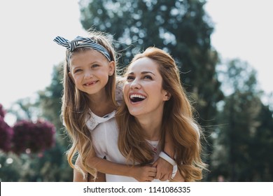 Walk In Park. Beautiful Mother And Daughter Feeling Relaxed And Relieved While Having Nice Walk In The Park