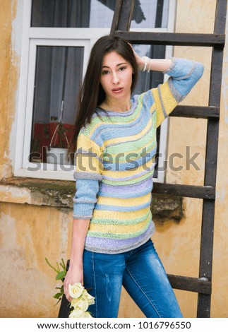 Walk, the Woman poses in a knitted sweater, expectation of spring