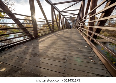 Walkers Cross A Foot Bridge On The Boise River