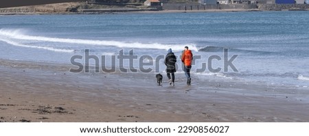 Walkers on a sandy beach on a sunny day in Summer