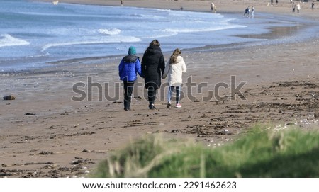 Walkers on a sandy beach on a sunny day in Summer