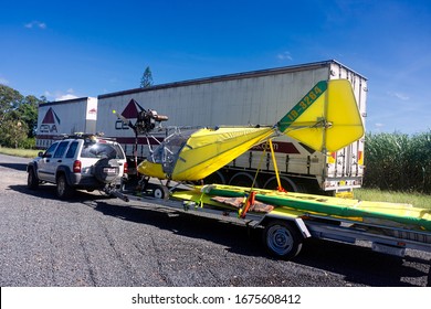 Walkerston, Queensland, Australia -March 16, 2020: A small bright yellow microlight aircraft being towed on a car trailer.