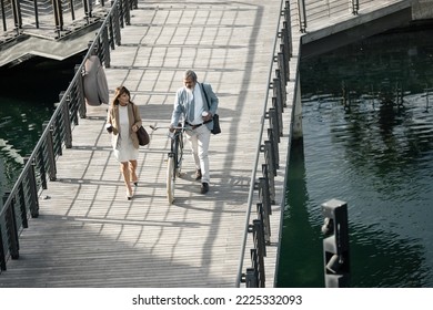 Walking, Bicycle And Team Of Business People Talking, Conversation Or Speaking While Travel On River Lake Bridge. Journey, Eco Friendly Transportation And Cycling Man And Senior Woman Commute To Work