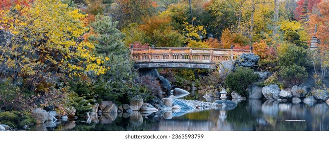 Walking bridge in scenic water fall Frederik Meijer gardens in autumn time in Grand Rapids, Michigan.